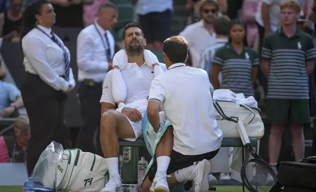 Serbia's Novak Djokovic gets treatment during a medical timeout break against Italy's Jannik Sinner in a men's singles semifinal at the Wimbledon Tennis Championships in London, Friday, July 11, 2025. (AP Photo/Kin Cheung)