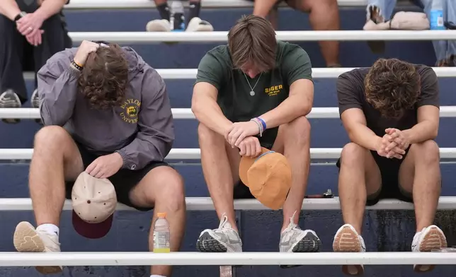 Attendees react during a vigil for flooding victims at Tivy Antler Stadium on Wednesday, July 9, 2025, in Kerrville, Texas. (AP Photo/Gerald Herbert)
