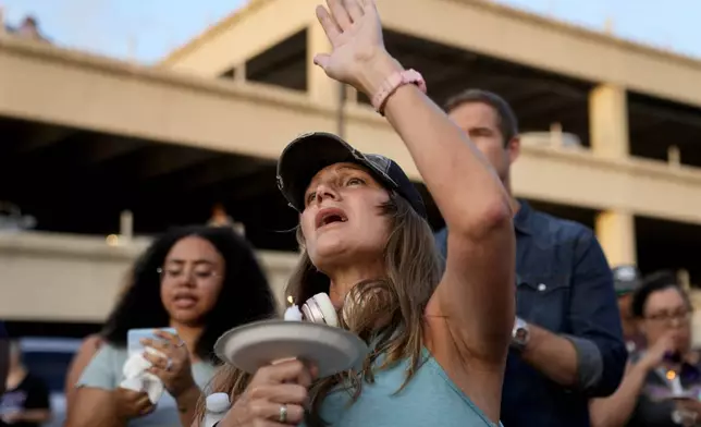 A mourner offers prayers to flood victims during a vigil on Friday, July 11, 2025, in Kerrville, Texas. (AP Photo/Gerald Herbert)
