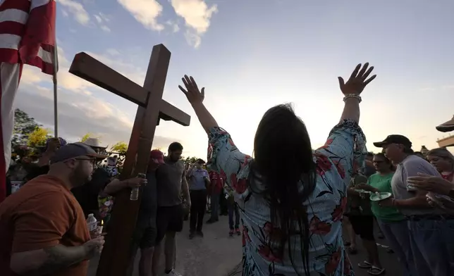 Mourners offer prayer during a vigil for flood victims on Friday, July 11, 2025, in Kerrville, Texas. (AP Photo/Gerald Herbert)