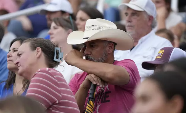 People attend a vigil for flooding victims at Tivy Antler Stadium on Wednesday, July 9, 2025, in Kerrville, Texas. (AP Photo/Ashley Landis)