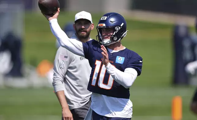 Denver Broncos quarterback Bo Nix, front, takes part in drills as quarterbacks coach Davis Webb looks on during an NFL football practice Friday, July 25, 2025, in Centennial, Colo. (AP Photo/David Zalubowski)