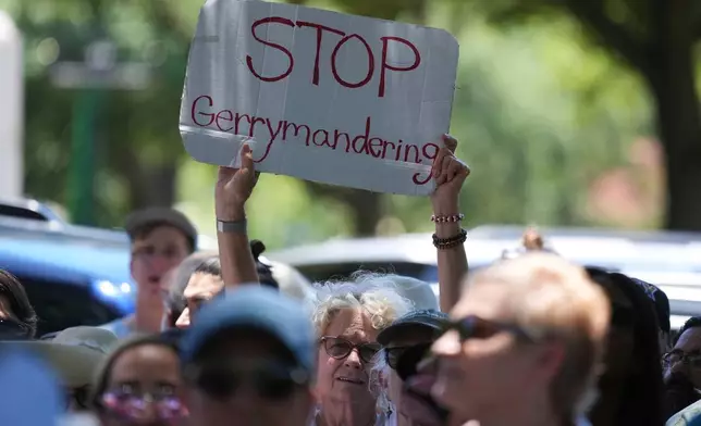 A woman holds a sign during a rally to protest against redistricting hearings at the Texas Capitol, Thursday, July 24, 2025, in Austin, Texas. (AP Photo/Eric Gay)