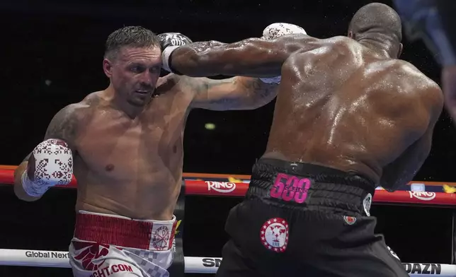 Ukraine's Oleksandr Usyk, left, and Britain's Daniel Dubois in action during the undisputed world heavyweight boxing title fight in London, Saturday, July 19, 2025. (AP Photo/Frank Augstein)
