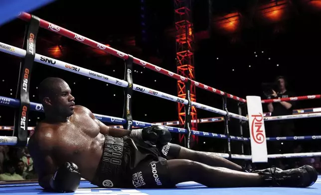 Daniel Dubois lies on the ring after a knockout by Ukraine's Oleksandr Usyk during their world heavyweight boxing title fight, in London, Saturday, July 19, 2025. (Bradley Collyer/PA via AP)