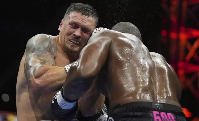 Ukraine's Oleksandr Usyk, left, and Britain's Daniel Dubois in action during the undisputed world heavyweight boxing title fight in London, Saturday, July 19, 2025. (AP Photo/Frank Augstein)