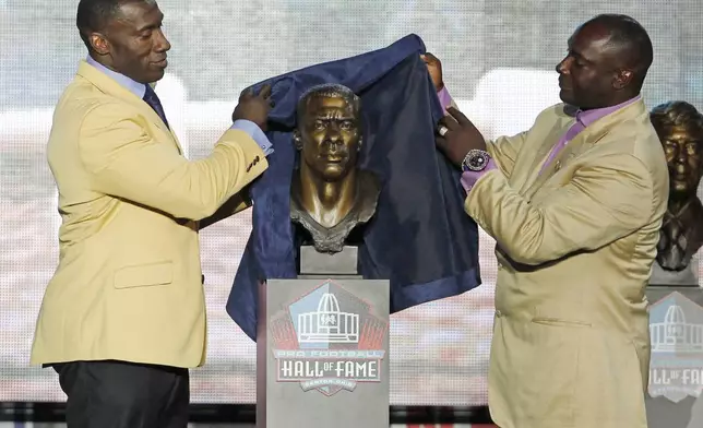 FILE - Shannon Sharpe, left, unveils a bust of himself along with his presenter and brother, Sterling Sharpe, during the induction ceremony at the Pro Football Hall of Fame, Saturday, Aug. 6, 2011, in Canton, Ohio. (AP Photo/Ron Schwane, File)