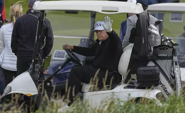 President Donald Trump waves to reporters as he sits in his golf cart at the Trump Turnberry golf course in Turnberry, Scotland, Saturday, July 26, 2025.(AP Photo/Alastair Grant)