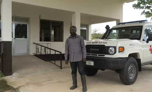 Adakemue Kollai, who worked implementing one of USAID's programs in Liberia, stands in front of an ambulance provided by USAID at the Phebe Hospital in Bong County, Liberia, Thursday, June 12, 2025. (AP Photo/Annie Risemberg)