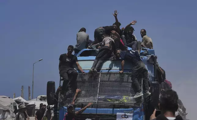 Palestinians hold onto an aid truck returning to Gaza City from the northern Gaza Strip on Tuesday, July 22, 2025. (AP Photo/Jehad Alshrafi)