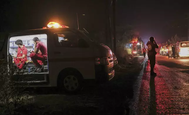 Syrian Civil Defense teams and volunteers battle wildfire flames for the tenth consecutive day near the town of Kasab, in Syria's Latakia countryside, early Saturday, July 12, 2025. (AP Photo/Ghaith Alsayed)