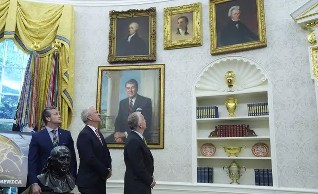 FILE - From left, Defense Secretary Pete Hegseth, Sen. Kevin Cramer, R-N.D., and Sen. Dan Sullivan, R-Alaska, look at portraits of former presidents as President Donald Trump speaks in the Oval Office of the White House, in Washington, May 20, 2025. (AP Photo/Alex Brandon, File)