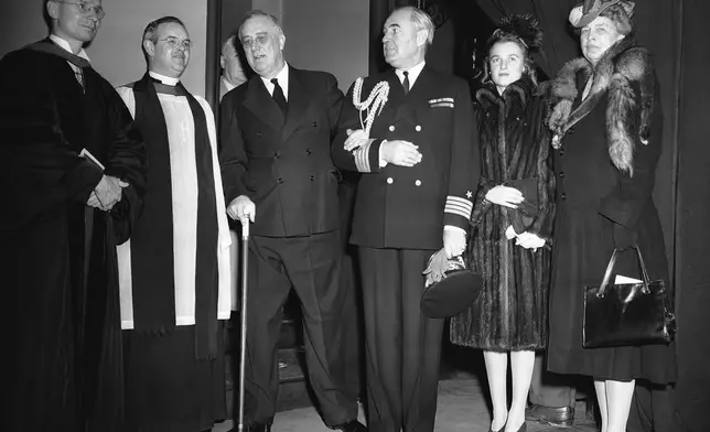 FILE - President Franklin D. Roosevelt, takes the arm of Capt. John L. McCrae, the president's Naval aide, as he leaves the Church of the Epiphany in Washington on Dec. 25, 1942, after attending Christmas church services accompanied by first lady Eleanor Roosevelt, right, and their daughter Ethel. (AP Photo/George R. Skadding)