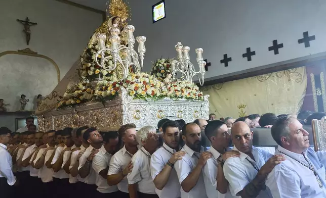 Catholic faithful carry a statue of the Virgin of Carmen during a religious procession in Estepona, southern Spain, Wednesday, July 16, 2025. (AP Photo/Claudia Rosel)