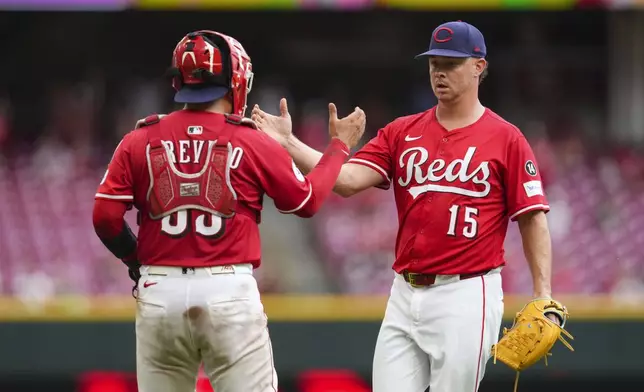 Cincinnati Reds' Emilio Pagán (15) celebrates with Jose Trevino, left, following a baseball game against the Tampa Bay Rays, Sunday, July 27, 2025, in Cincinnati. (AP Photo/Jeff Dean)