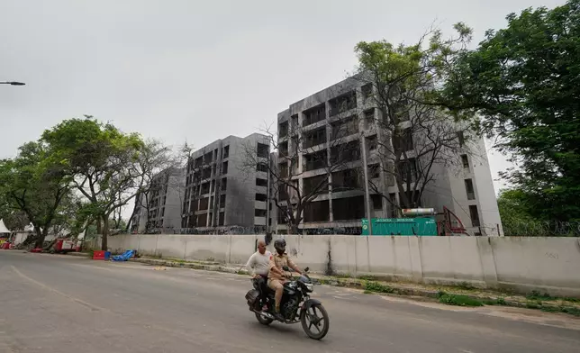 Policemen ride past buildings damaged in the June 12 Air India plane crash in Ahmedabad, India, Saturday, July 12, 2025. (AP Photo/Ajit Solanki)
