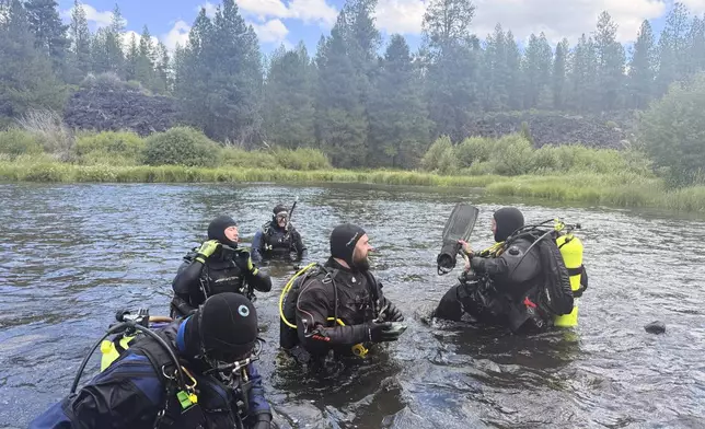 In this photo provided by the Deschutes, Ore., County Sheriff's Office, divers search for those missing following a fatal waterfall accident on Saturday, July 19, 2025, at Dillon Falls, near Bend, Ore. (Deschutes County Sheriff's Office via AP)