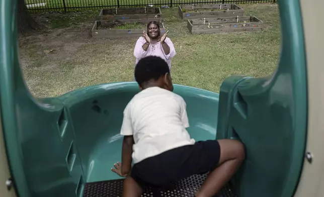Aaliyah Barnes cheers as her son, Aarmoni Barnes, plays on the playground at the Stoddard Johnston Scholar House, Friday, July 11, 2025, in Louisville, Ky. (AP Photo/Jon Cherry)