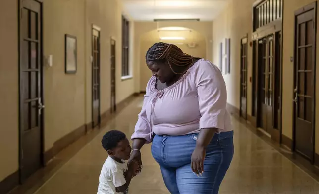 Aaliyah and Aarmoni Barnes stand in the hallway near their apartment at the Stoddard Johnston Scholar House, Friday, July 11, 2025, in Louisville, Ky. (AP Photo/Jon Cherry)