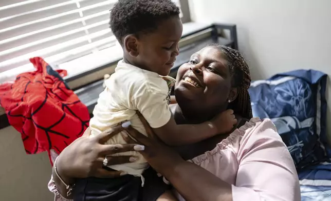 Aaliyah and Aarmoni Barnes play in his room in their apartment at the Stoddard Johnston Scholar House, Friday, July 11, 2025, in Louisville, Ky. (AP Photo/Jon Cherry)