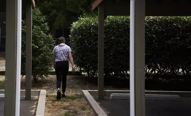 Havalah Hopkins, a single mother who lives in government-subsidized housing with her teenage son, goes to check on her son playing outside Thursday, July 10, 2025, in Woodinville, Wash. (AP Photo/Lindsey Wasson)