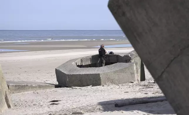 A gendarme stands in a WWII nazi bunker at Ecault beach, Friday July 4, 2025. (AP Photo/John Leicester)