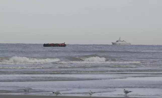A French Navy vessel sails by a "Taxi boat" carrying migrants, Friday July 4, 2025 on Hardelot beach south of Boulogne-sur-Mer, northern France. (AP Photo/John Leicester)