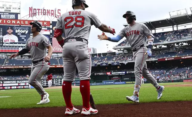 Boston Red Sox's Trevor Story, right, celebrates after his two-run home run with Abraham Toro (29) during the first inning of a baseball game against the Washington Nationals, Sunday, July 6, 2025, in Washington. (AP Photo/Nick Wass)