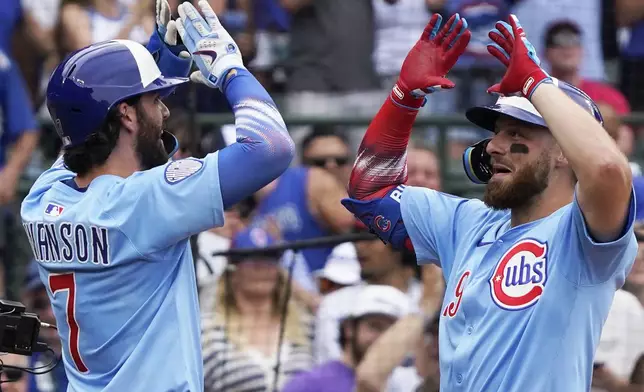 Chicago Cubs' Michael Busch, right, is greeted by Dansby Swanson (7) after hitting a two-run home run against the St. Louis Cardinals during the third inning of a baseball game Friday, July 4, 2025, in Chicago. (AP Photo/David Banks)