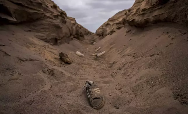 A shoe lies in a ditch along a route used by migrants near the border crossing into Peru, in Arica, Chile, Tuesday, June 10, 2025.(AP Photo/Esteban Felix)
