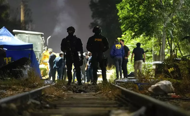 FILE - Police and forensic investigators work in the area where the body of former Venezuelan military officer Ronald Ojeda, who was kidnapped eight days earlier, was found in Santiago, Chile, March 1, 2024. (AP Photo/Esteban Felix, File)