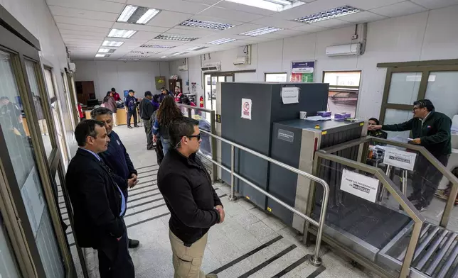 Prosecutor Bruno Hernandez, left, watches customs inspections underway at Chacalluta border between Chile and Peru in Arica, Tuesday, June 10, 2025. (AP Photo/Esteban Felix)