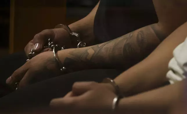 Alleged members of the Tren de Aragua sit handcuffed during a preliminary hearing where they face homicide charges, in Santiago, Chile, July 9, 2025. (AP Photo/Esteban Felix)