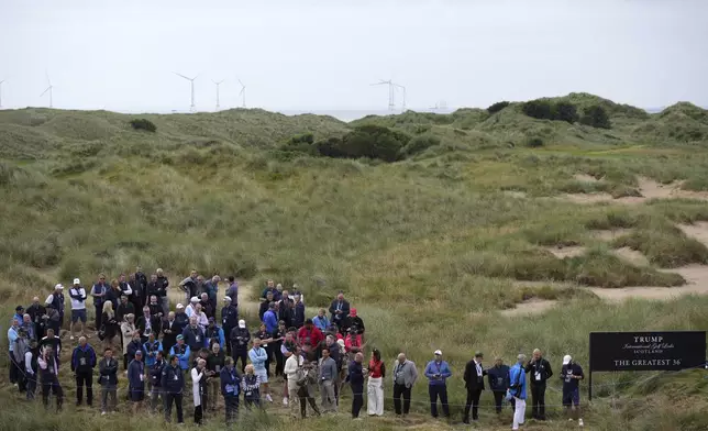 Guests await President Donald Trump attending an opening ceremony for Trump International Golf Links near Aberdeen, Scotland Tuesday, July 29, 2025.(AP Photo/Alastair Grant)
