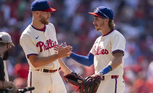 Philadelphia Phillies' Zack Wheeler, left, celebrates with Bryson Stott, right, following a baseball game against the Cincinnati Reds, Sunday, July 6, 2025, in Philadelphia. (AP Photo/Chris Szagola)