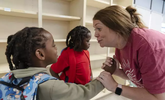 Jillian Murphy high-fives Gaizka Accius, 6, after working through a math problem during the East Providence Boys and Girls Club Summer Camp at Emma G. Whiteknact Elementary School on Thursday, July 10, 2025, in Providence R.I. (AP Photo/Sophie Park)