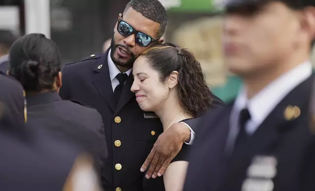 A New York Police officer greets colleagues and friends before attending the funeral for officer Didarul Islam, Thursday, July 31, 2025, in New York. (AP Photo/Angelina Katsanis)