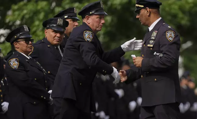 New York Police Deputy Inspector Muhammad Ashraf, right, of the 47th Precinct is greeted by colleagues outside the Parkchester Jame Masjid mosque before the funeral of officer Didarul Islam, Thursday, July 31, 2025, in New York. (AP Photo/Angelina Katsanis)
