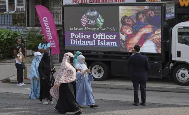 Women arrive at the Parkchester Jame Masjid mosque before the funeral of officer Didarul Islam, Thursday, July 31, 2025, in New York. (AP Photo/Angelina Katsanis)