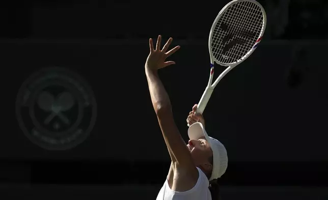Poland's Iga Swiatek serves to Switzerland's Belinda Bencic during a women's singles semifinal match at the Wimbledon Tennis Championships in London, Thursday, July 10, 2025. (AP Photo/Kin Cheung)