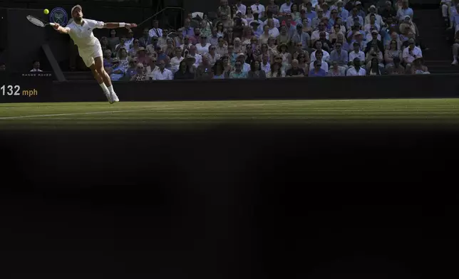 Serbia's Novak Djokovic returns to Italy's Jannik Sinner in a men's singles semifinal at the Wimbledon Tennis Championships in London, Friday, July 11, 2025. (AP Photo/Kin Cheung)