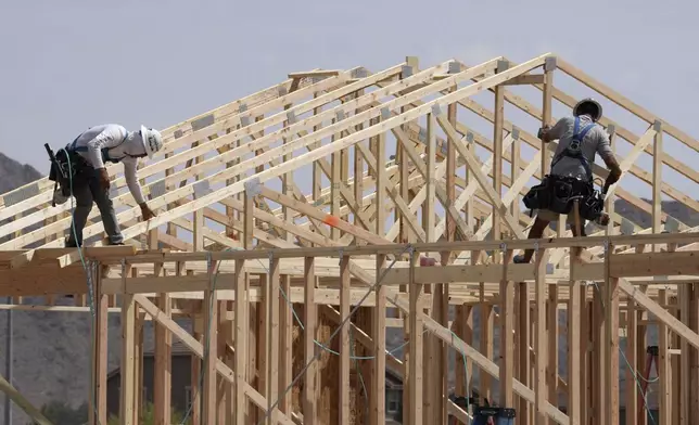 FILE - Construction workers frame up a roof of wood lumber at a new home build, April 1, 2025, in Laveen, Ariz. (AP Photo/Ross D. Franklin, File)