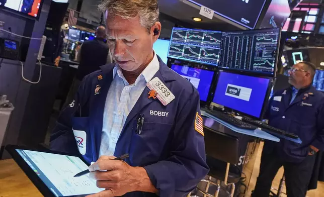 Trader Robert Charmak, left, works on the floor of the New York Stock Exchange, Tuesday, July 8, 2025. (AP Photo/Richard Drew)