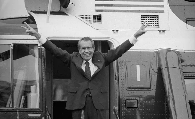 FILE - Richard Nixon salutes his staff members outside the White House as he boards a helicopter after resigning the presidency on Aug. 9, 1974. (AP Photo/Bob Daugherty, File)