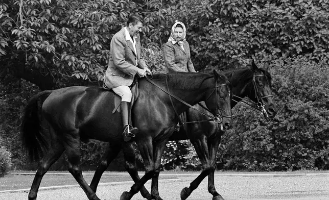 FILE - U.S. President Ronald Reagan and Britain's Queen Elizabeth II ride horses through the grounds of Windsor Castle, in Windsor, England. (AP Photo/Bob Daugherty, File)