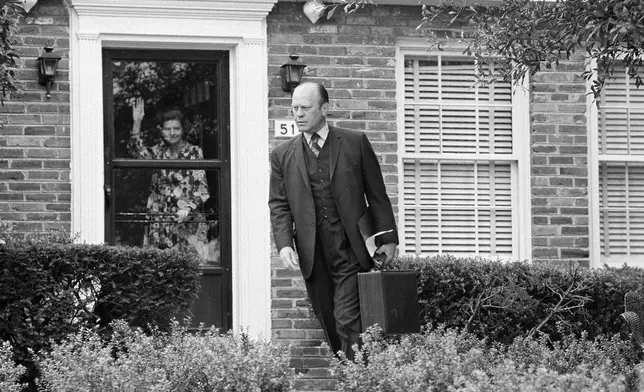 FILE - Betty Ford waves goodbye to her husband, President Gerald Ford, as he leaves their Alexandria, Va., home, Aug. 13, 1974, on his way to the White House. (AP Photo/Bob Daugherty, File)