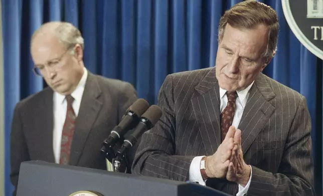 FILE - U.S. President George H. Bush speaks to reporters at the White House in Washington, on Thursday, Nov. 8, 1990, accompanied by Defense Secretary Dick Cheney, left, during Operation Desert Shield in the Persian Gulf. (AP Photo/Bob Daugherty, File)