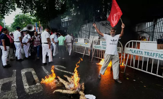 A supporter of Centre of India Trade Unions, CITU, shouts slogans as an effigy of Indian Prime Minister burns during a nation-wide strike to protest what they call the anti-labor and anti-poor policies of the federal government, in Kolkata, India, Wednesday, July 9, 2025. (AP Photo/Bikas Das)