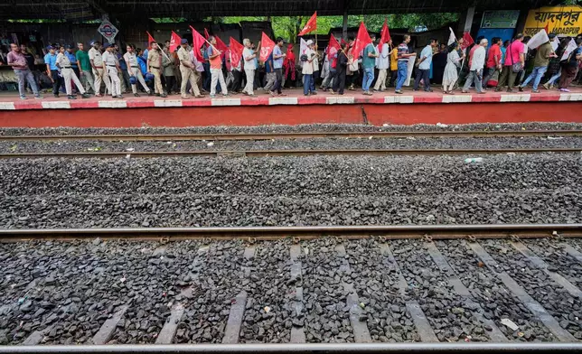Supporters of Centre of India Trade Unions, CITU, walk in a rally on a railway station platform during a nation-wide strike to protest what they call the anti-labor and anti-poor policies of the federal government, in Kolkata, India, Wednesday, July 9, 2025. (AP Photo/Bikas Das)