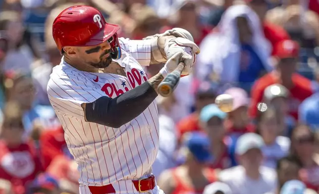 Philadelphia Phillies' Nick Castellanos hits an RBI single in the third inning of a baseball game against the Cincinnati Reds, Friday, July 4, 2025, in Philadelphia. (AP Photo/Laurence Kesterson)